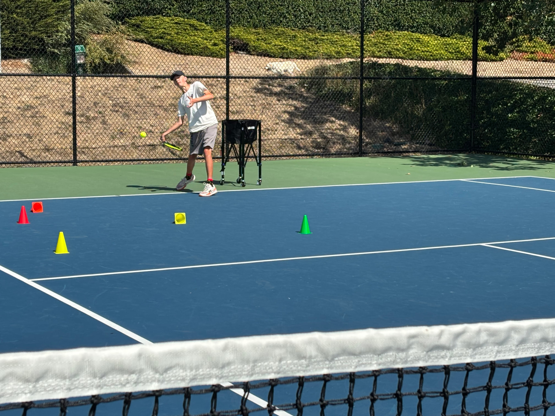 Oliver Talbot hitting a forehand during a lesson on a Victoria tennis court